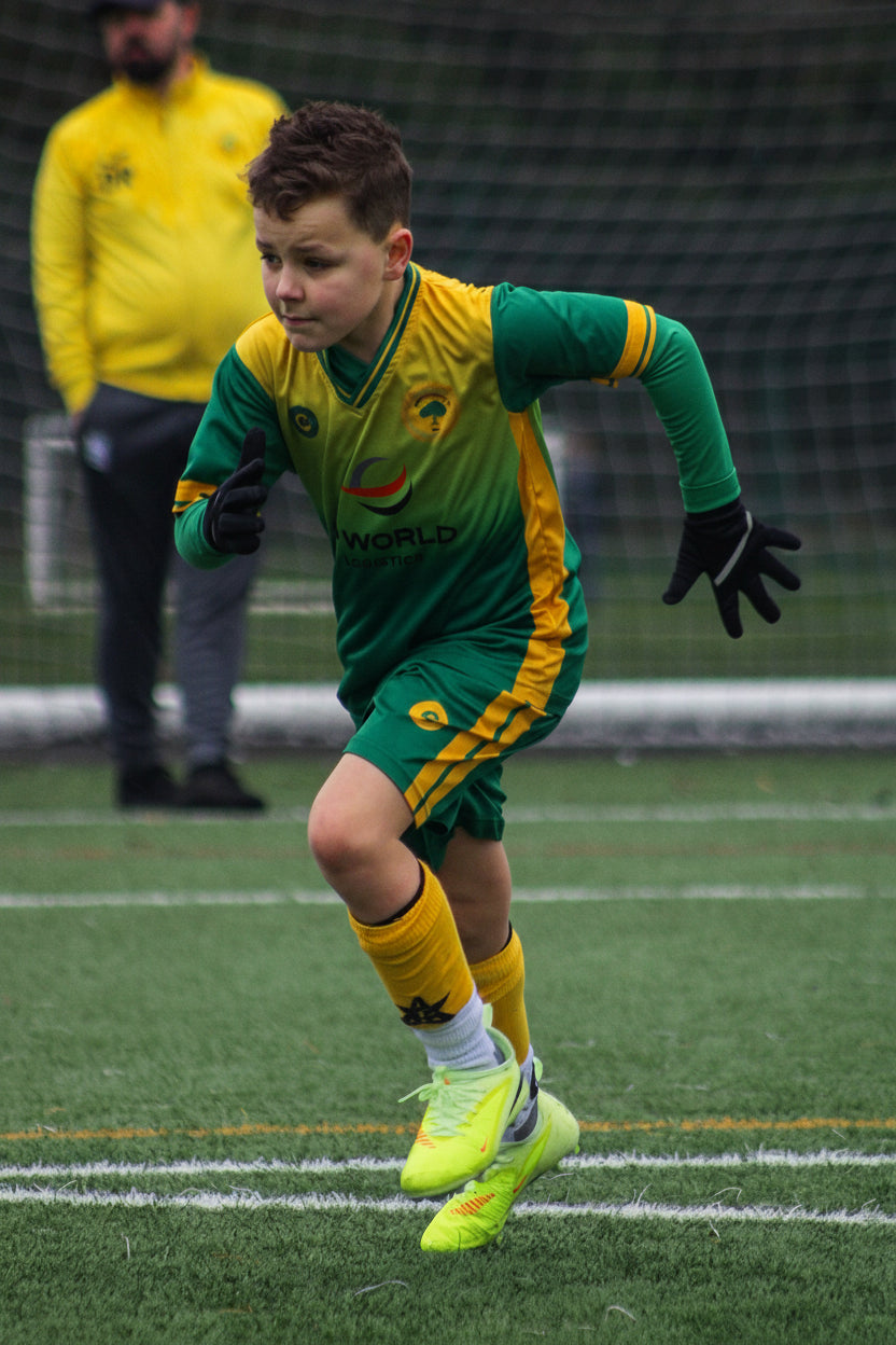 Soccer player in green and yellow uniform on a field